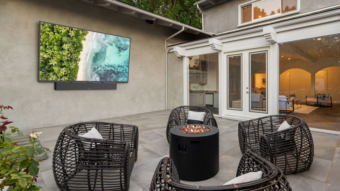 Outdoor seating area with a TV mounted on the wall.